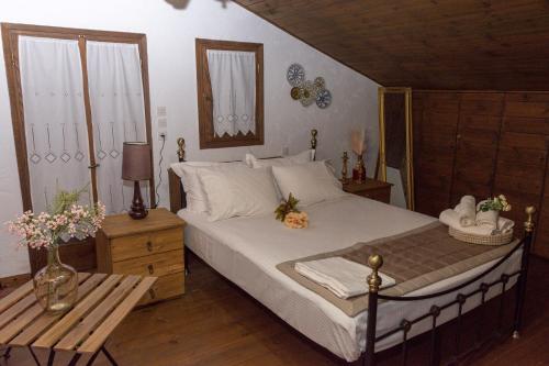 Arxontiko Palamas في Palamás: غرفة نوم بسرير وطاولة مع ورد