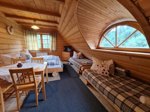 una habitación con 2 camas y una mesa en una cabaña en GliczarowSki u Zbója, en Zakopane