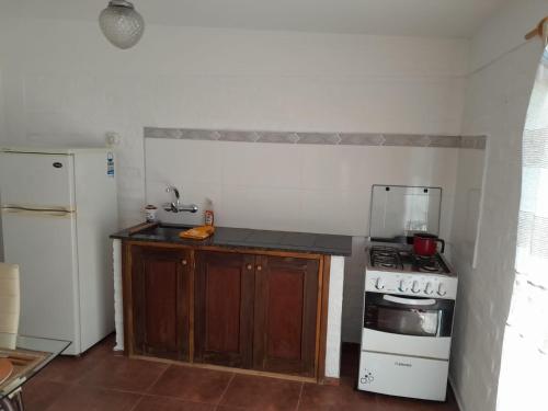 a kitchen with a stove and a white refrigerator at Apartamento en Colonia in Colonia del Sacramento