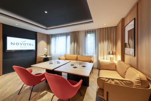 a living room with a table and chairs and a couch at Novotel Suites Paris CDG Airport Villepinte in Roissy-en-France