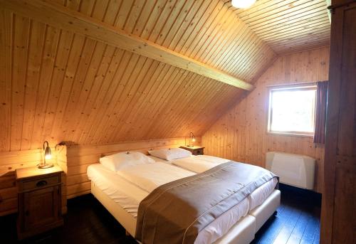 a bed in a room with a wooden ceiling at 't Eekhoornnest in Soest