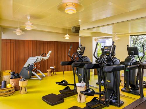 un gimnasio con cintas de correr y máquinas elípticas en Too Hotel Paris - MGallery, en París