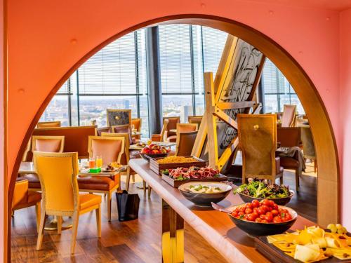 une salle à manger avec une table et des bols de nourriture dans l'établissement Too Hotel Paris - MGallery, à Paris
