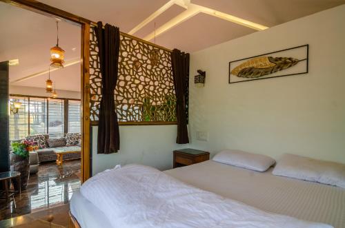 a bedroom with a bed and a large window at Malhar Villa -Kashid in Kashid