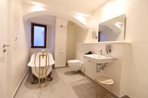 a white bathroom with a sink and a toilet at Das Fischer Boardinghouse KF in Kaufbeuren