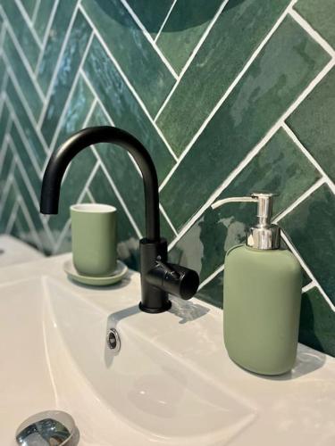 un lavabo de salle de bain avec un distributeur de savon dessus dans l'établissement L'Odyssée, à Saint-Étienne