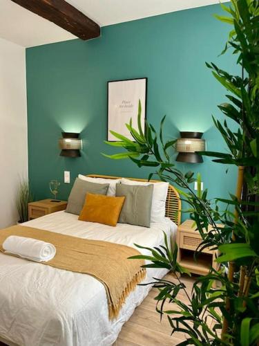 une chambre avec un lit avec un mur bleu dans l'établissement L'Odyssée, à Saint-Étienne