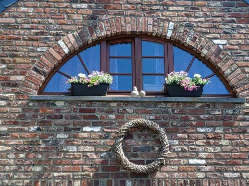 une fenêtre avec deux plantes en pot et un miroir dans l'établissement A l'ombre du noyer, à Fernelmont