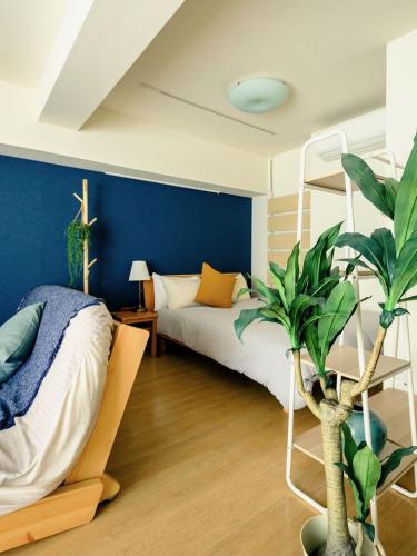a bedroom with a bed and a blue wall at Home n Lounge in Tokyo