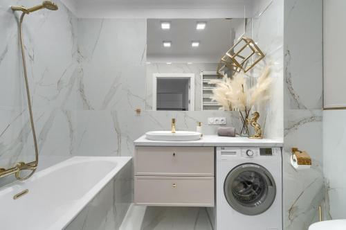 斯塞新的住宿－Apartament Gold LUX AIRCON，白色的浴室设有洗衣机和水槽。