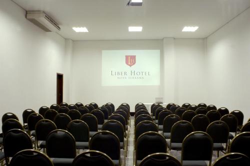 an empty lecture room with chairs and a screen at Líber Hotel Nova Serrana in Nova Serrana