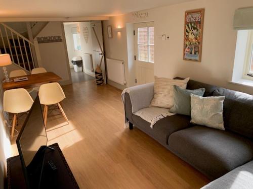 a living room with a couch and a table at The Studio in Ashton Keynes