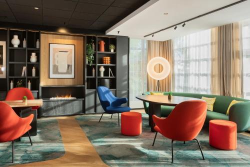 a lobby with a table and chairs and a fireplace at Novotel Suites Paris CDG Airport Villepinte in Roissy-en-France