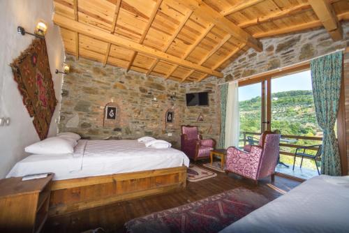 a bedroom with two beds and chairs and a window at Heaven's Gate in Sirince