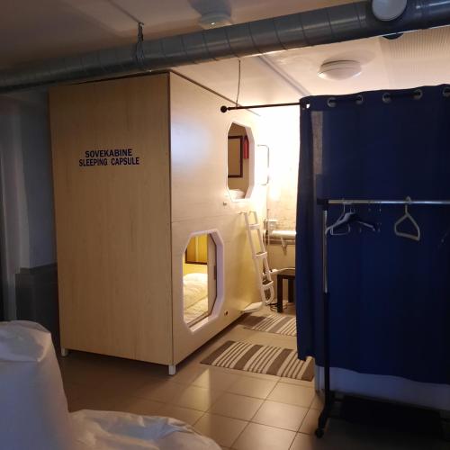 Habitación pequeña con una puerta que conduce a un dormitorio. en Wooden box with sleeping amenities Vindegade 53E, en Odense