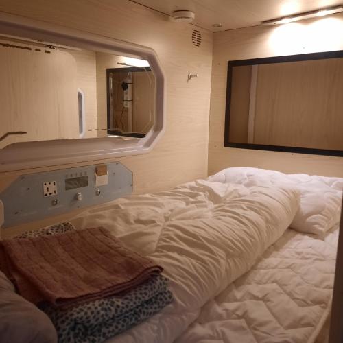uma grande cama branca num quarto com um espelho em Wooden box with sleeping amenities Vindegade 53E em Odense