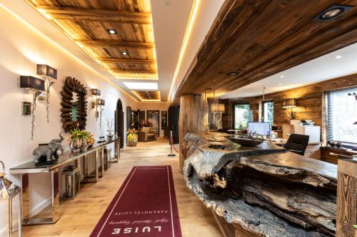 a lobby with a large log wall and wooden ceilings at Waldhotel Luise in Freudenstadt