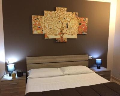 a bedroom with a bed and two lamps and a clock at albergo Elena 3 SELF CHECK-IN in Parma