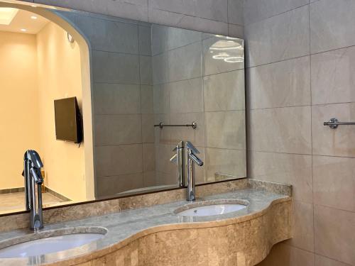 two sinks in a public bathroom with a mirror at Pool Villa Saraya in Ras al Khaimah