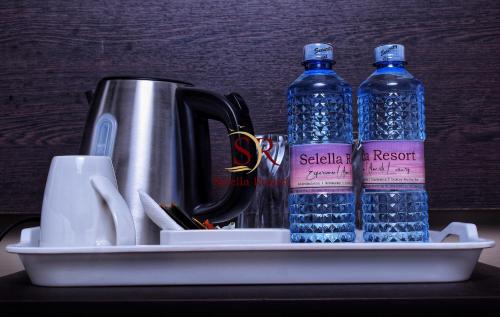 a tray with two bottles of water and a kettle at Selella Resort in Kisumu
