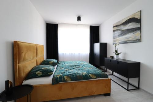 a bedroom with a bed and a dresser and a window at MBV28 Apartments in Poprad