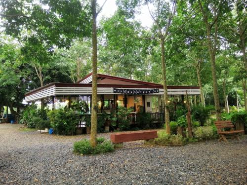 a small building in the middle of a park at Sameikei Homestay in Phrae