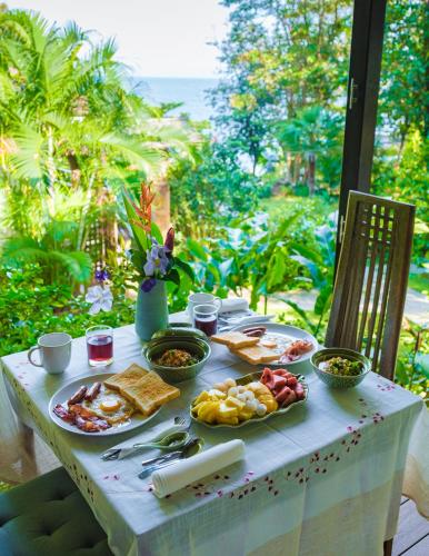 a table with breakfast food on it with a view of the ocean at Jasmin Garden Koh Kood in Ko Kood