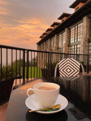 a cup of coffee sitting on a table on a balcony at Hotel Mirador de la Cepada in Cangas de Onís