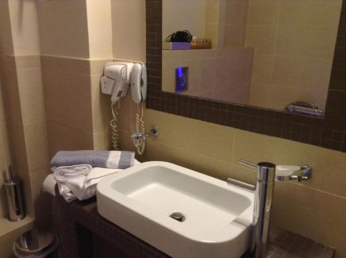 a bathroom with a sink and a phone on the wall at Amfitriti Palazzo in Nafplio