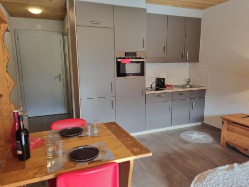 eine kleine Küche mit einem Tisch und einer Arbeitsplatte in der Unterkunft Magnifique studio rénové au coeur des 4 Vallées in Nendaz