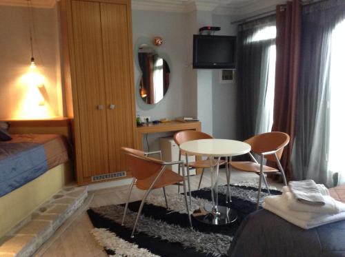 a room with a table and chairs and a bed at Amfitriti Palazzo in Nafplio