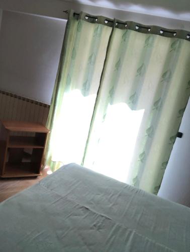 a bedroom with a bed and a window with curtains at Appartamento Diana in Roccaraso