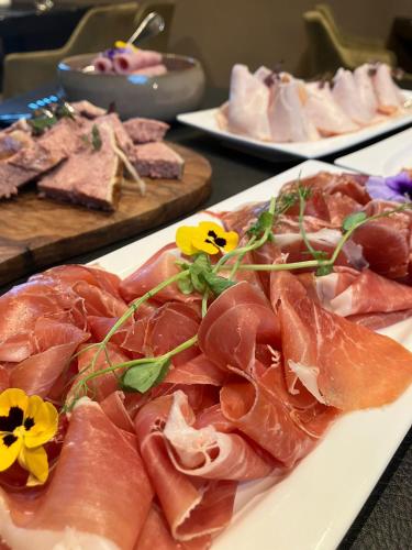 a plate of food with meat and flowers on it at B&B Herenhuis in Izegem