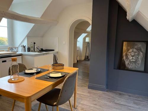 a kitchen and dining room with a wooden table and chairs at Appartement avec terrasse en plein cœur de Vernon in Vernon