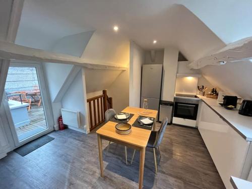 a dining room with a table and a kitchen at Appartement avec terrasse en plein cœur de Vernon in Vernon