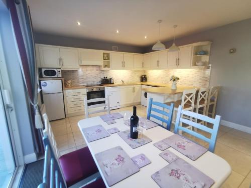 a kitchen with a table with a bottle of wine on it at Molly's Cottage Lahinch in Lahinch