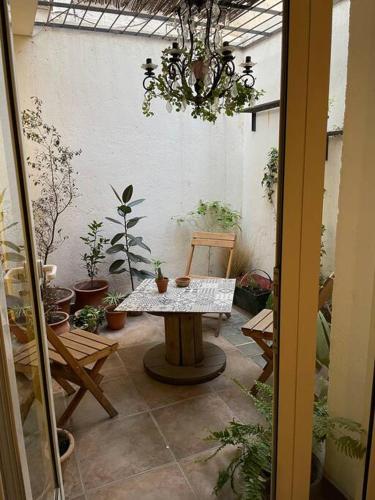 un patio con una mesa y un montón de macetas en Hermoso departamento céntrico, con estacionamiento en Mendoza