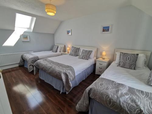 a bedroom with two beds and two lamps in it at Molly's Cottage Lahinch in Lahinch