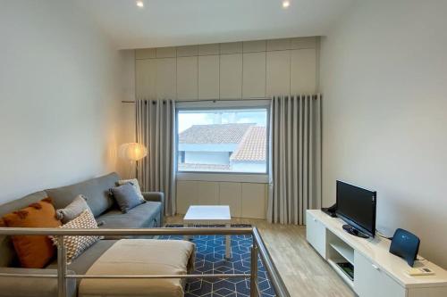 a living room with a couch and a tv at Casa do Mar South in Ponta Delgada