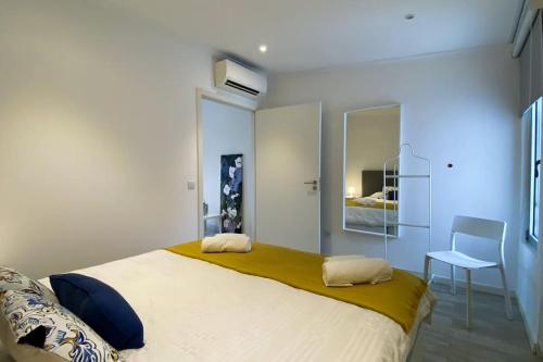 a bedroom with a large bed and a chair at Casa do Mar South in Ponta Delgada