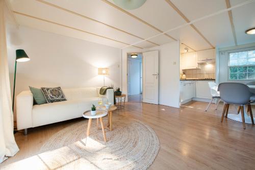 a living room with a couch and a table at 84, gelegen in het rustige & bosrijke Oisterwijk! Met privétuin in Oisterwijk