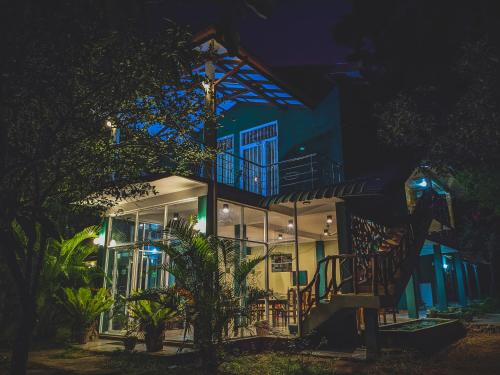 a building with a staircase in front of it at night at Choona Lodge 'view of sigiriya & pidurangala with sunrise' in Sigiriya