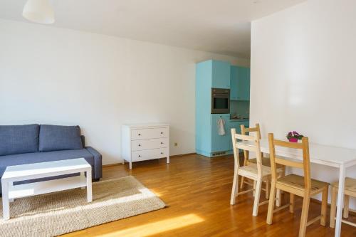 - un salon avec un canapé bleu, une table et des chaises dans l'établissement Vienna Living Apartments - Lerchenfelder Straße, à Vienne