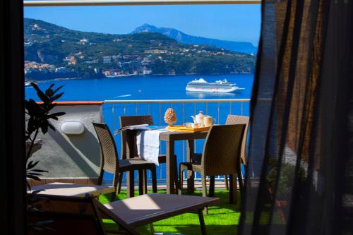 a balcony with a table and chairs and a cruise ship at Dreamers' Escape in Vico Equense