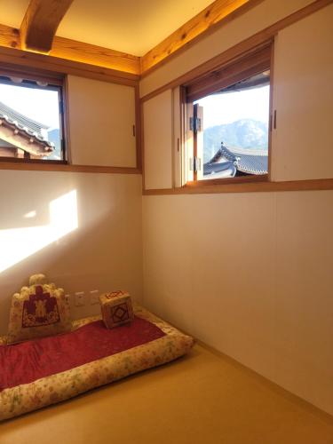 a room with a bed and two windows at Chaehyodang Hanok Stay in Seoul