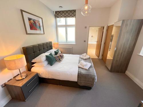 a bedroom with a bed and a lamp on a table at Urban Living's - Windsor Castle Luxury Apartments in Windsor