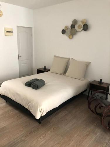 1 dormitorio con 1 cama con sábanas blancas y 2 mesas en Appartement en duplex à Auxonne, en Auxonne