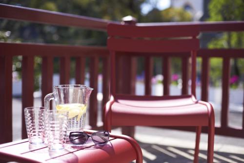 a table with glasses and a glass of lemonade on a chair at Hôtel Le Saint Christophe in La Baule