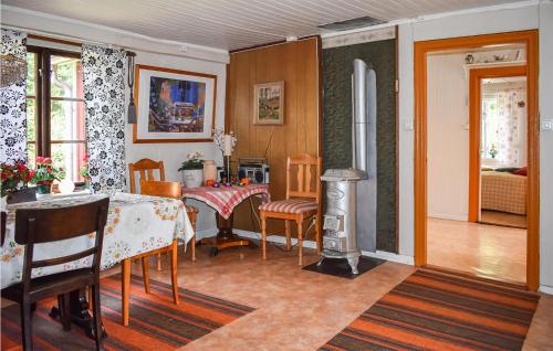 Il comprend un salon avec une table et des chaises ainsi qu'une cuisine. dans l'établissement Cozy Home In Hstveda With House A Panoramic View, à Hästveda