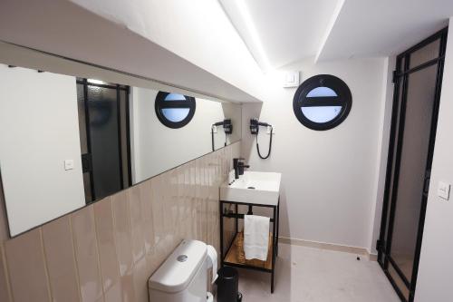a bathroom with a toilet and a sink and mirrors at Mythic Valencia in Valencia